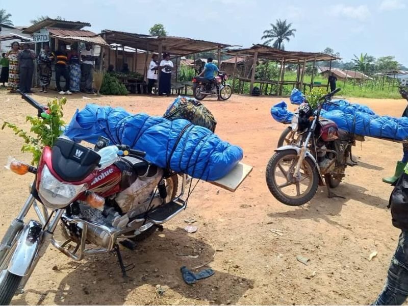 Comunidade devastada no leste da rdc após ataques, com pessoas desabrigadas entre ruínas.