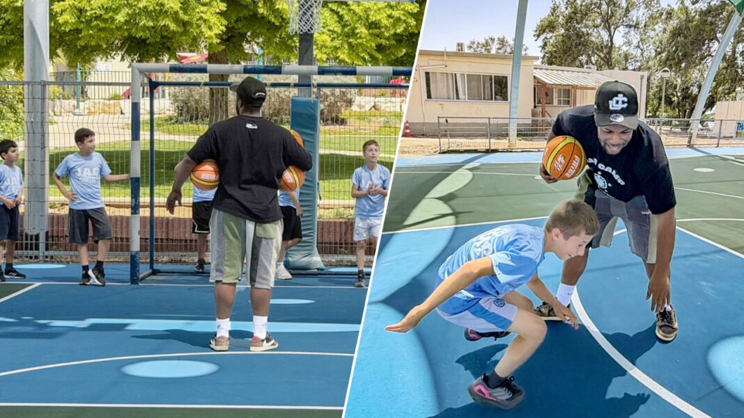 Crianças jogando basquete em uma quadra renovada em Kibutz Zikim, Israel, com o jogador americano Jared Armstrong