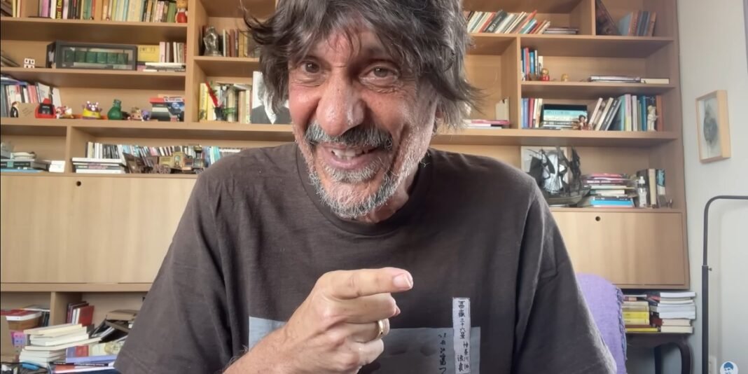 Escritor Eduardo Bueno em ambiente sério, com expressão grave, representando a acusação de discriminação religiosa.
