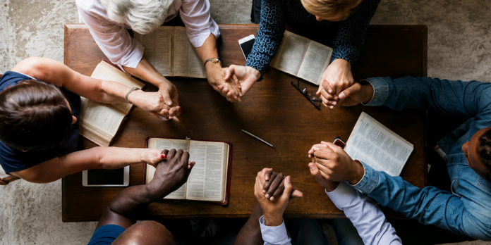 Comunidade e esperança: grupo de apoio cristão em ação Grupo de apoio cristão compartilhando experiências em uma sala de igreja, demonstrando compaixão e conexão.