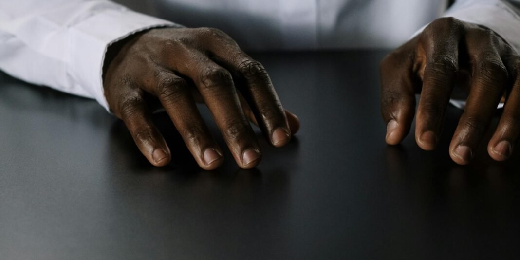 Homem ugandense com mãos enfaixadas em um hospital após ataque