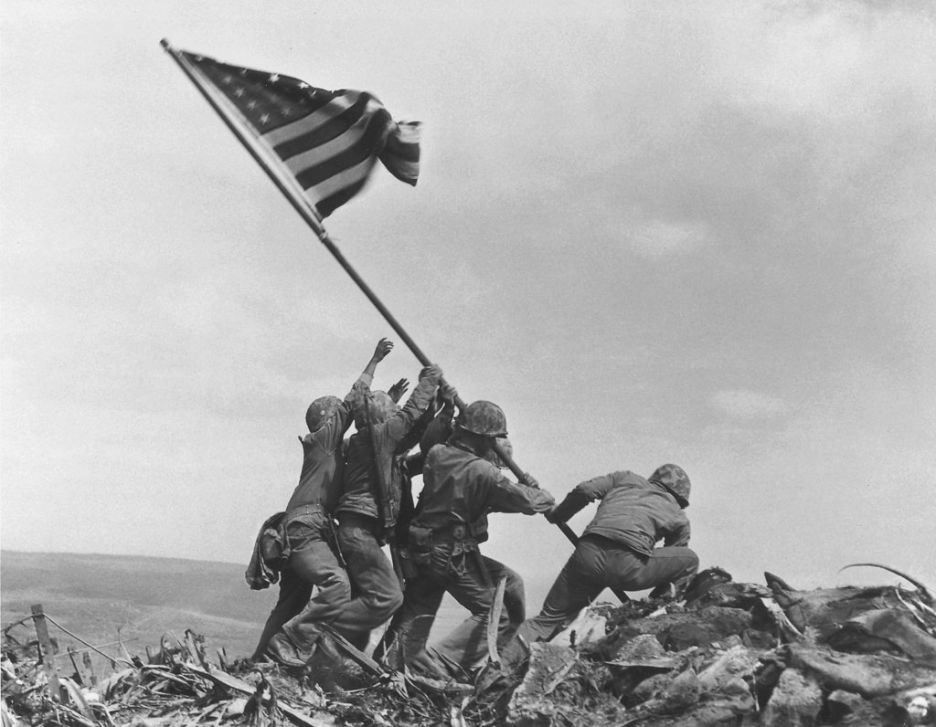 Veteranos idosos em Iwo Jima observando o oceano em memória da batalha.