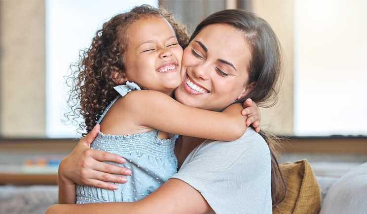 Mãe cristã abraçando seus dois filhos, demonstrando amor e conexão familiar.
