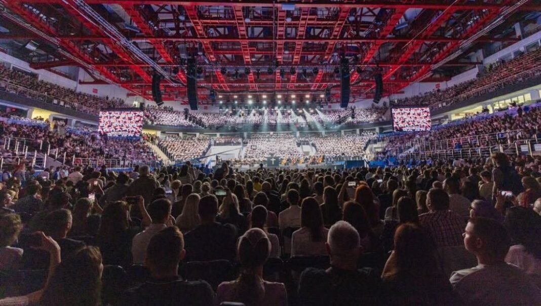 Multidão de pessoas participando de um grande evento evangélico na Bielorrússia.