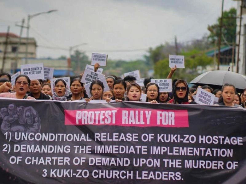 Manifestantes pacíficos em rua de Manipur, Índia, clamando por paz e a libertação de reféns.