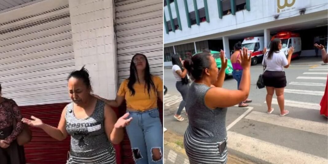 Mãe em oração com familiares e amigos em frente a hospital