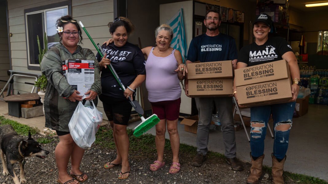Voluntário da Operation Blessing entrega ajuda a família afetada por enchentes no Havaí.