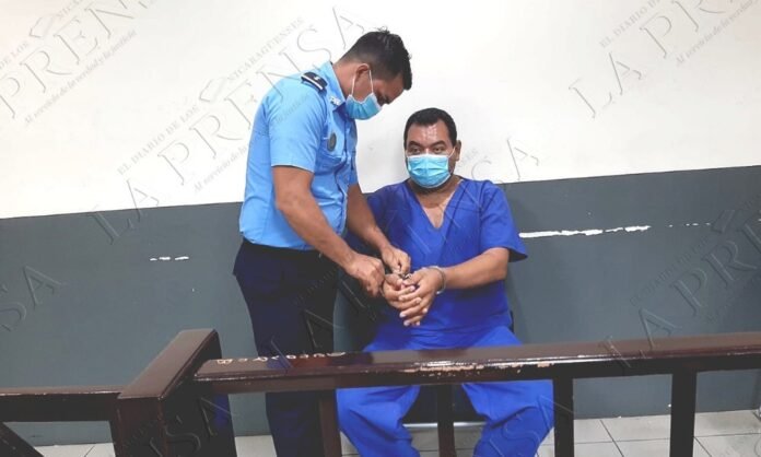 Pastor evangélico dentro de cela de prisão na Nicarágua segurando uma Bíblia.
