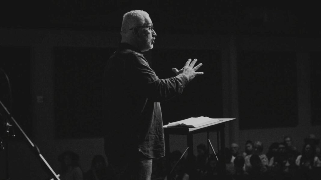 Pastor refletindo em seu escritório, com expressão mista de cansaço e esperança, indicando a complexidade do ministério.