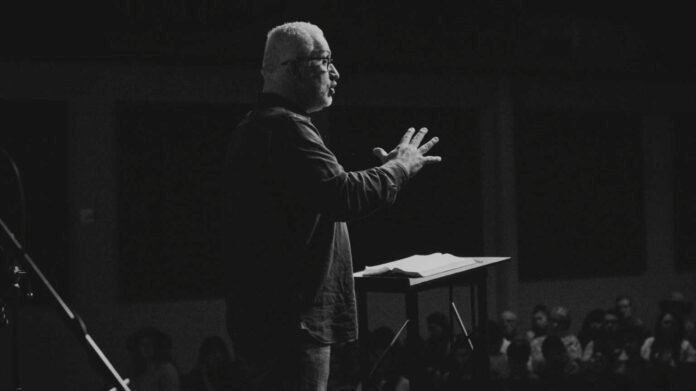 Pastor refletindo em seu escritório, com expressão mista de cansaço e esperança, indicando a complexidade do ministério.