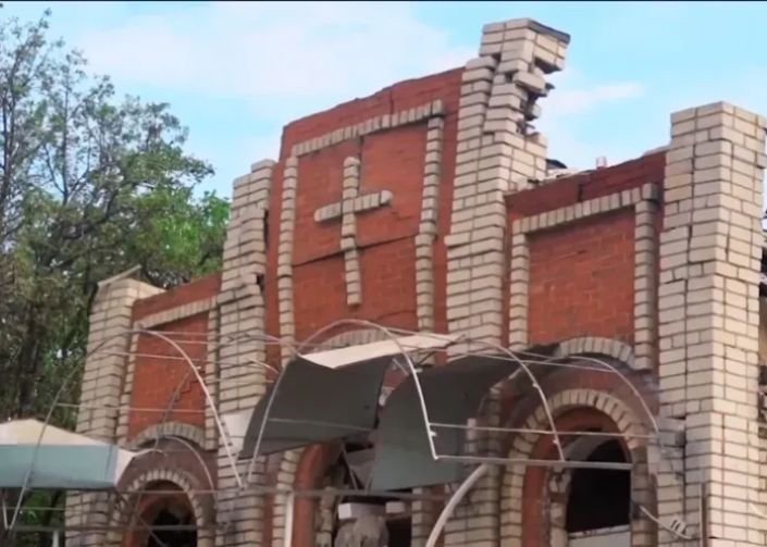 Igreja na Ucrânia danificada por ataque aéreo russo, com telhado e janelas destruídos.