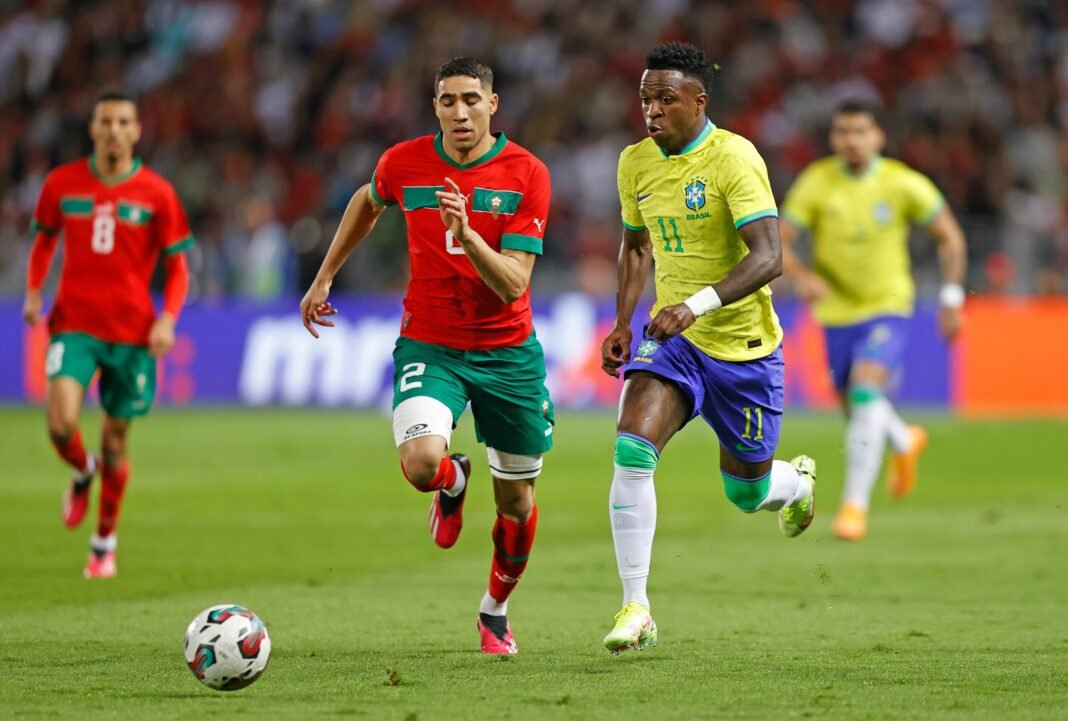 Torcedores de diferentes países assistem a um jogo da Copa do Mundo com expressões variadas.