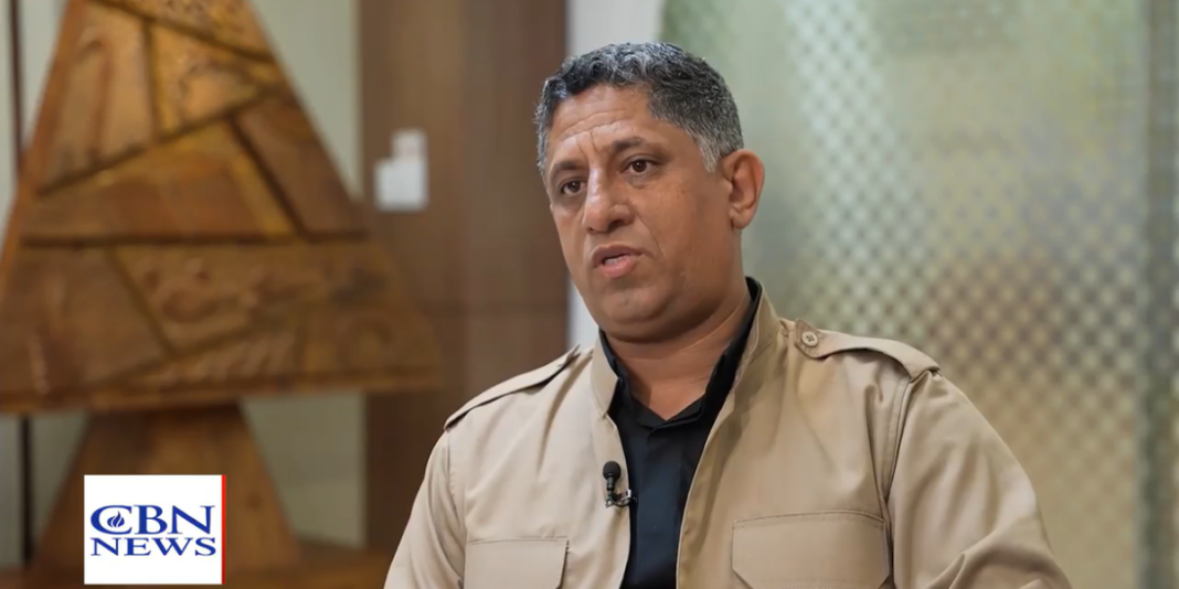 Pastor Nihad compartilhando seu testemunho em uma sala de espera.