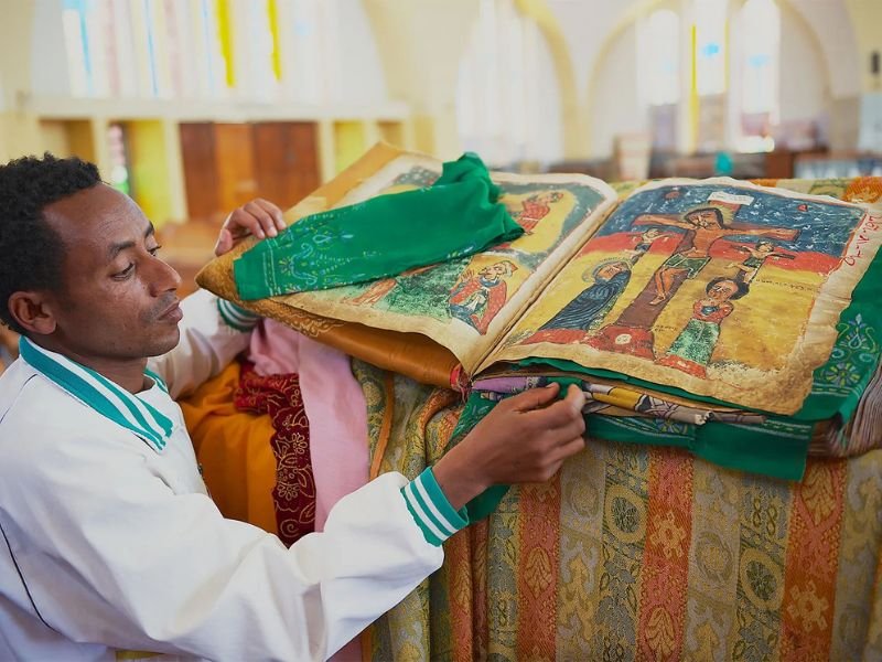 Homem etíope crente em Jesus, olhando para frente com expressão de fé e resiliência em meio a um cenário rural.