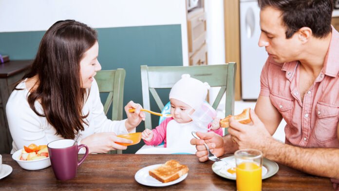 Introdução alimentar precoce de ovo em bebês. Mãe oferece ovo cozido a bebê para introdução alimentar precoce.