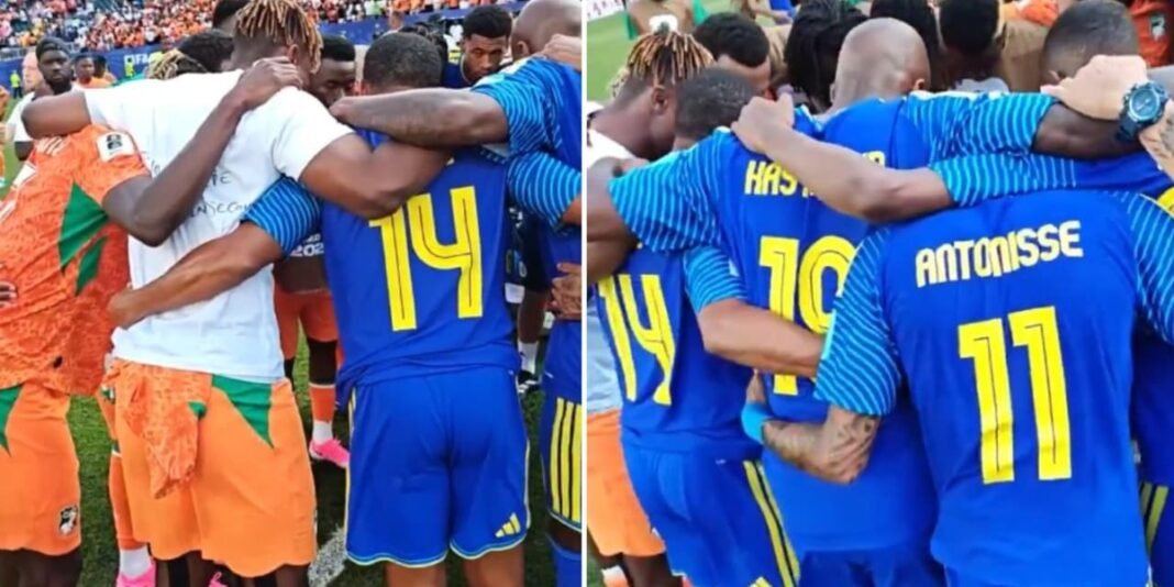 Jogadores de Curaçao e Costa do Marfim em círculo de oração no campo após partida da Copa do Mundo.