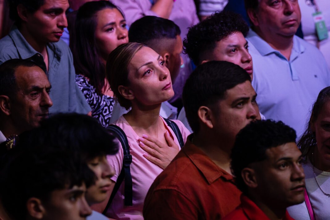 Multidão em evento evangelístico em Madri ouvindo pregador