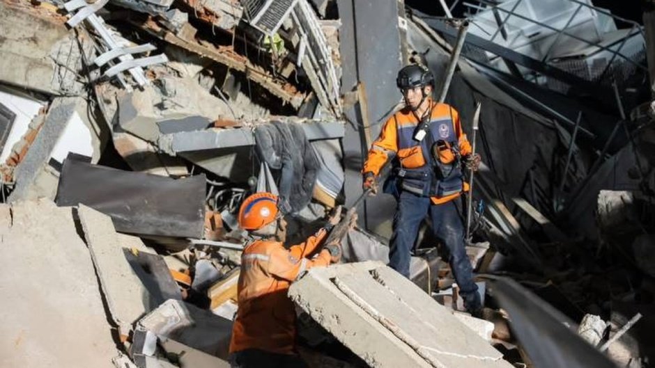 Equipe de ajuda humanitária em meio a escombros de prédios após terremoto na Venezuela