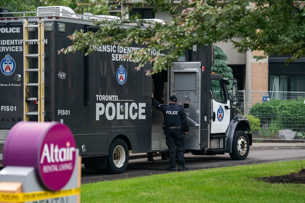Cena de crime em frente a um prédio governamental no Canadá, com presença policial.