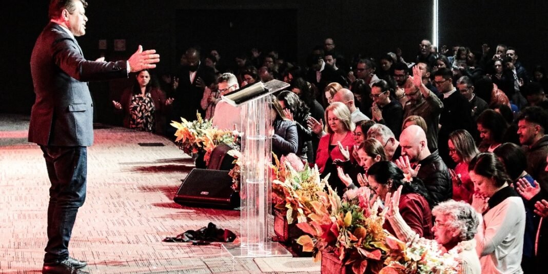 Pastor Edmar Moreira discursando em um púlpito de igreja.