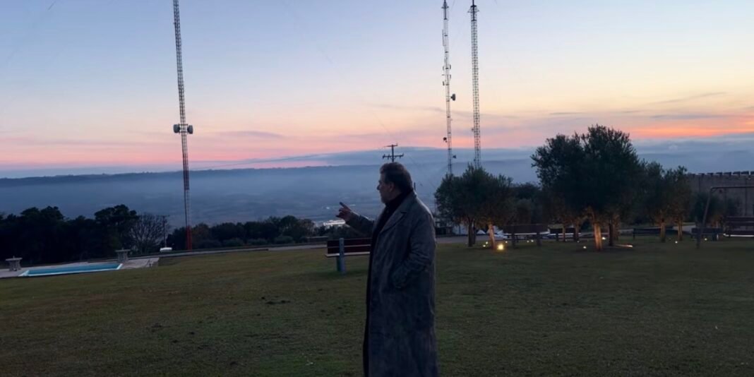 Pastor Joel Engel em oração dentro de uma cabana simples, transmitindo serenidade.