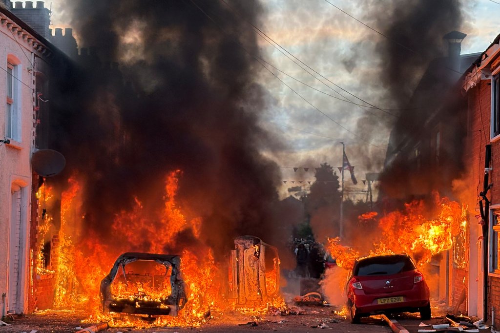 Carros em chamas em rua residencial na Irlanda do Norte durante protestos