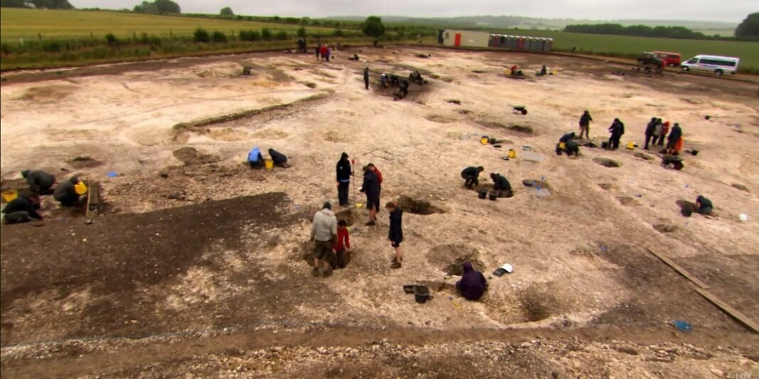 Arqueólogos examinando fragmentos de tecido púrpura em túmulo romano