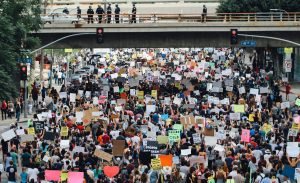 Rua dividida nos EUA com manifestantes de diferentes espectros políticos em lados opostos.