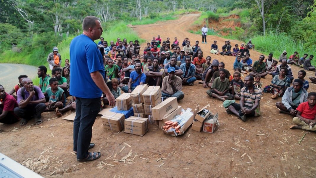 Casal missionário ucraniano interagindo com crianças em vilarejo na Papua Nova Guiné.