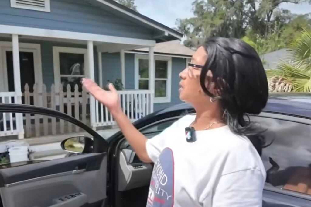 Casa destruída por queda de árvore na Flórida, com mulher expressando alívio.