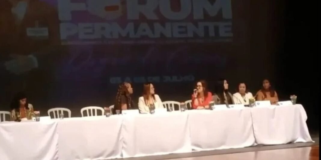 Promotora de justiça em evento público, com expressão séria.