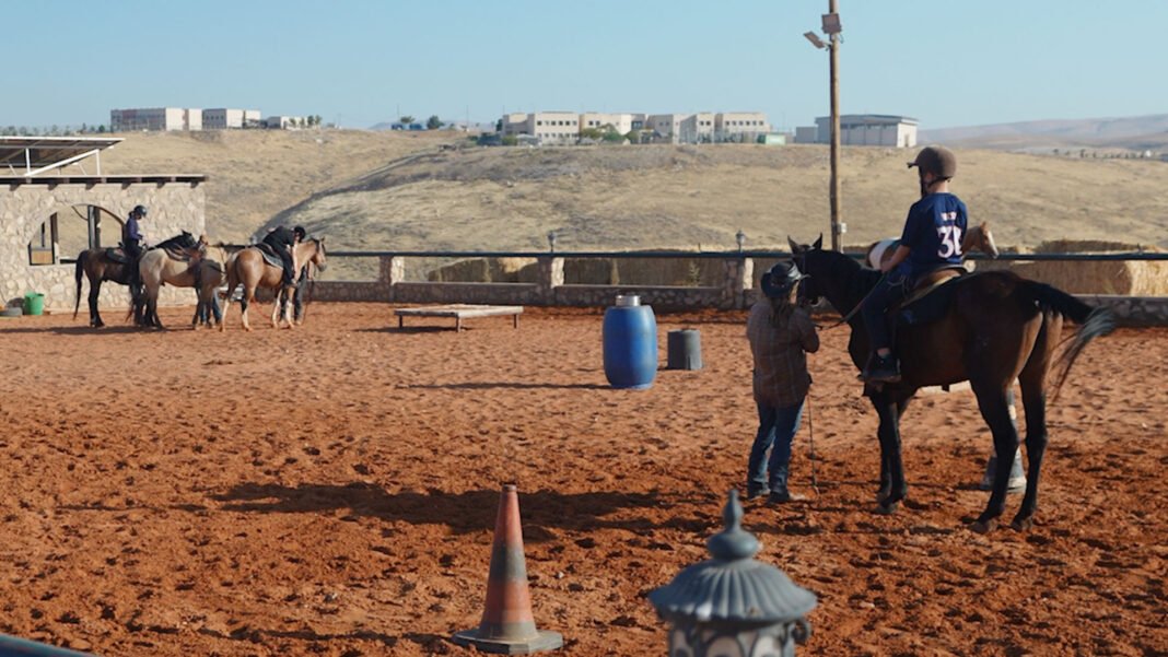 Soldado israelense recebe conforto de um cavalo em rancho terapêutico