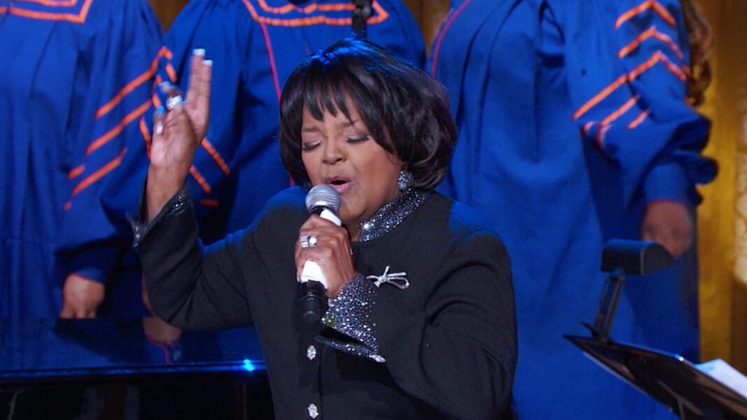 Shirley Caesar segurando um Grammy com um sorriso no estúdio de gravação.