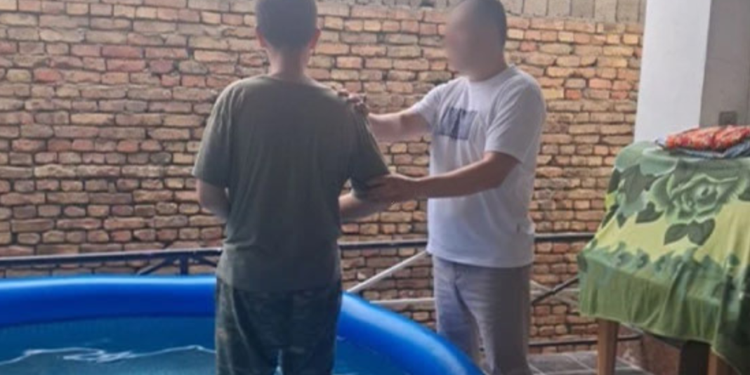 Jovem asiático com expressão pensativa em iluminação dramática.