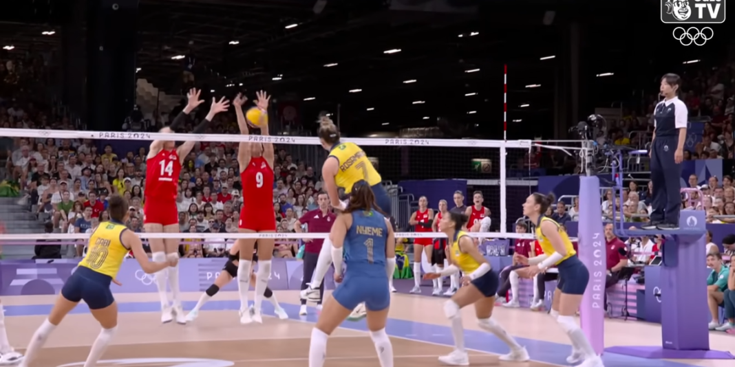 Jogadoras de vôlei feminino em ação durante uma partida profissional.