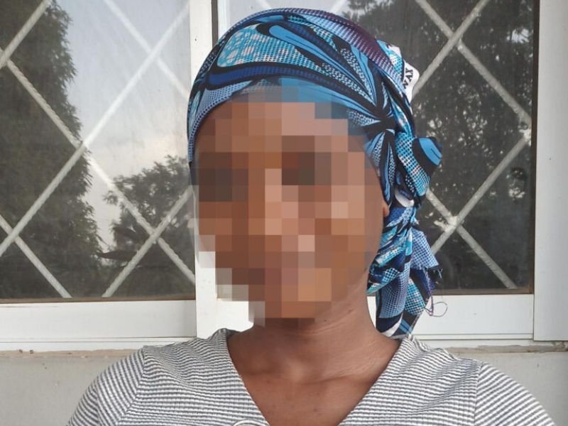 Mulher nigeriana com expressão de alívio em tribunal após decisão favorável