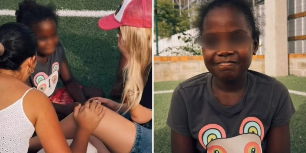 Menina daltônica olhando para um arco-íris vibrante após ser curada, com missionários emocionados ao fundo.