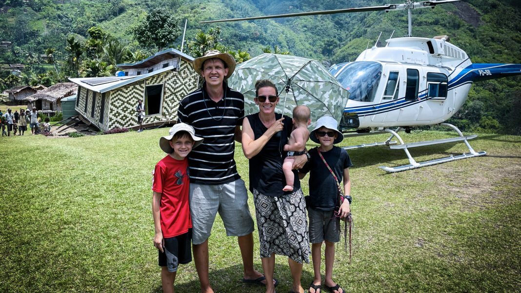 Helicóptero da JAARS pousando em vila remota na Papua Nova Guiné, recebido por moradores locais.