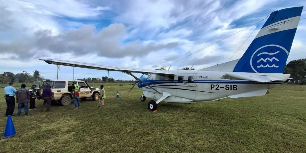 Avião missionário pousando em pista remota em meio à floresta tropical.