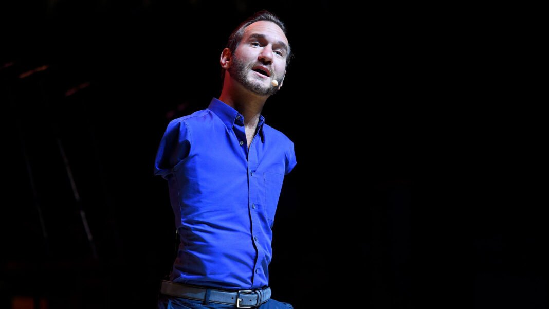 Nick Vujicic palestrando em um evento, transmitindo mensagem de inspiração.
