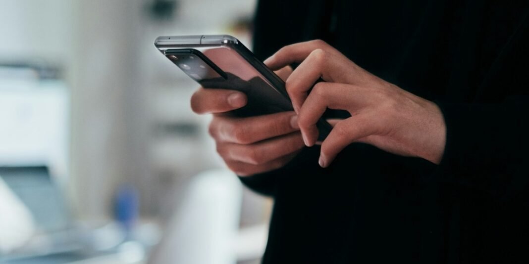 Smartphone exibindo o Evangelho de João em um aplicativo, representando o alcance digital da leitura bíblica.