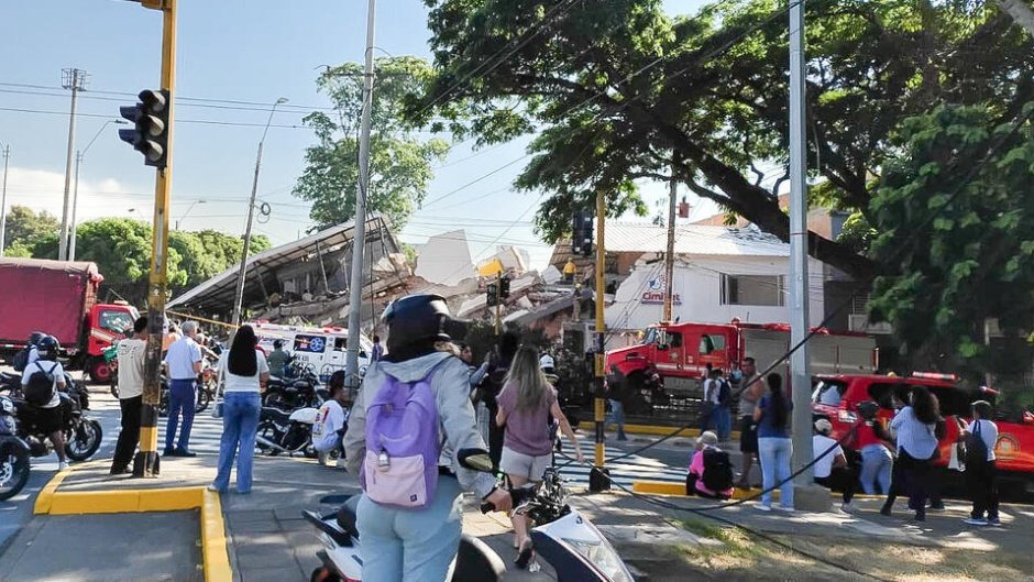 Prédio desmoronado após terremoto na Colômbia, com pessoas observando a destruição.