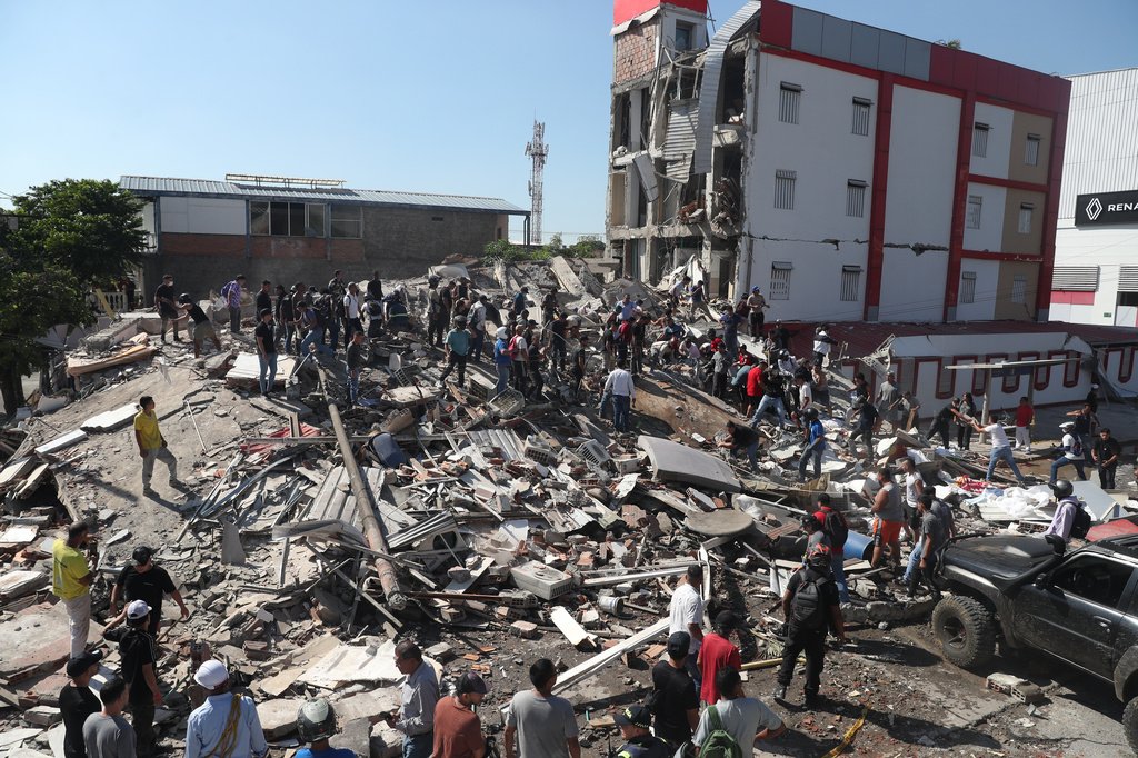 Cidades colombianas em ruínas após forte terremoto, com edifícios desabados e escombros nas ruas.