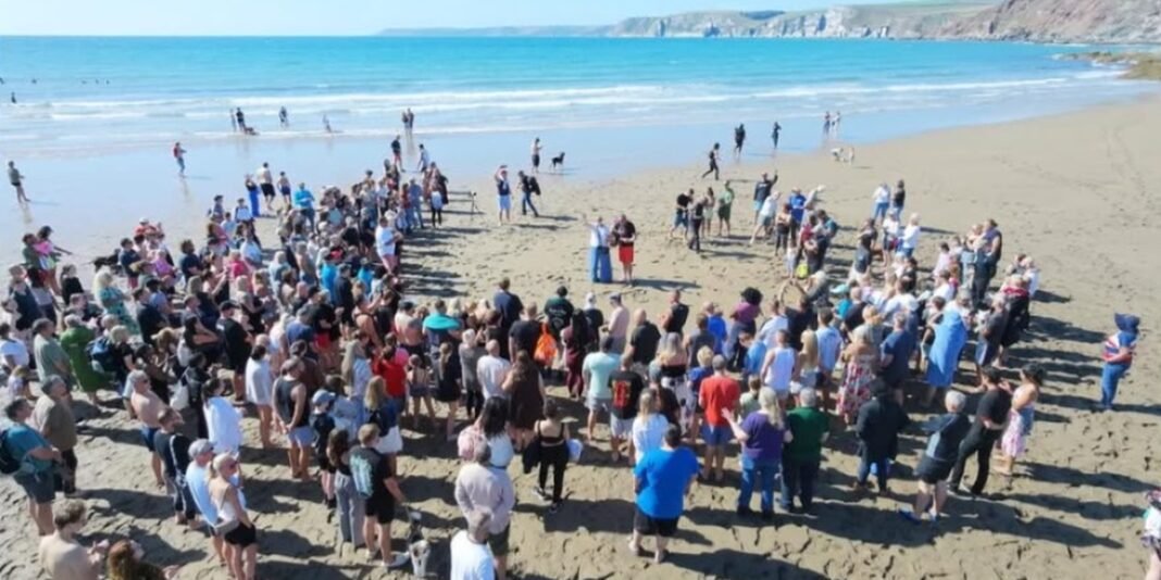 Cerimônia de batismo coletivo em praia na Inglaterra