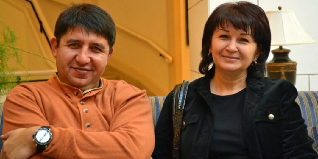 Casal de origem uzbeque segurando uma Bíblia em um momento de reflexão.