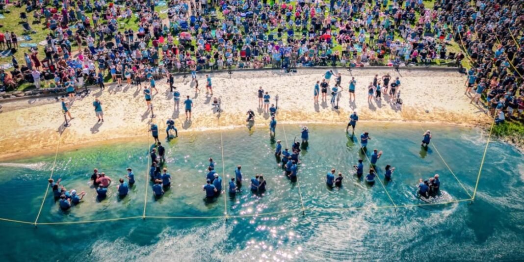 Fiéis aguardando batismo nas águas de um lago durante evento da Biltmore Church