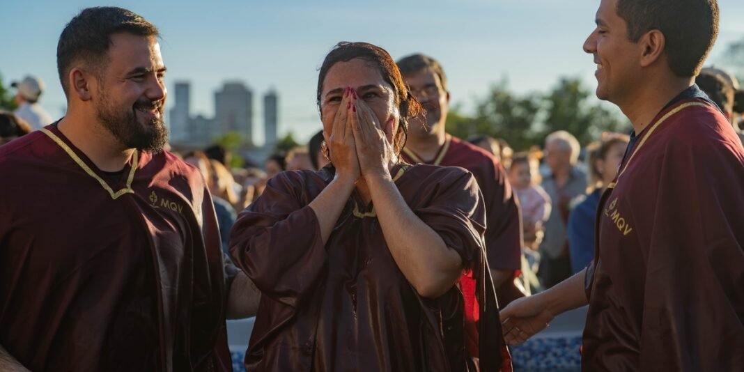Fiéis participando de cerimônia de batismo nas águas em igreja no Paraguai