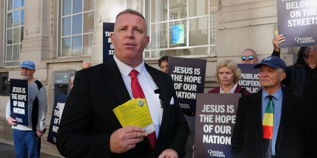 Pastor pregando em rua na Inglaterra cercado por cidadãos